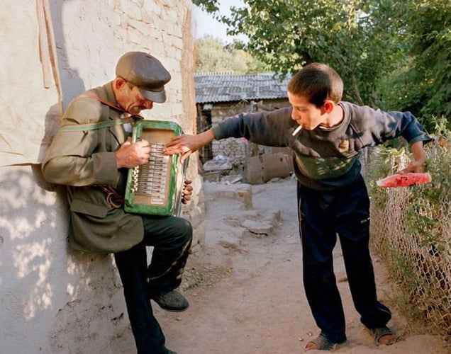 Yanush helps his grandfather play the broken accordion. Yampil, Ukraine, 2005. From the series "From the Mountains and to the Sea" © Nadia Sablin