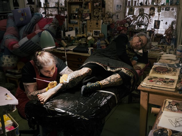 Lois tattooing her mother Carey in her home studio