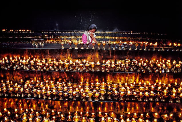 Lhasa, Tibet: A girl in front of the famous Jokhang temple is carefully filling the candles with yak oil, for they should never die out. © Matjaz Krivic
