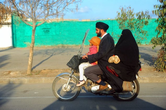 An Iranian Shiite Mullah rides his motorbike with his wife and child in the holy city of Qom, situated 120 km to the south of Tehran.  Qom, IRAN - December 2008
© Copyright 1979-2009 Alfred Yaghobzadeh. All rights reserved.