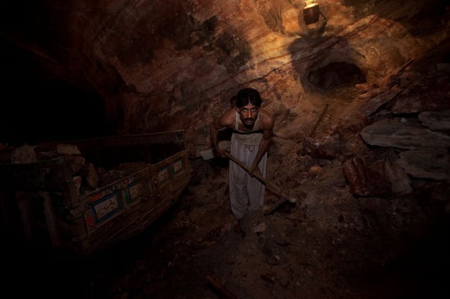 A salt miner loads a truck with rock salt after blasting the salt from the mine walls with dynamite at the Warcha salt mine.