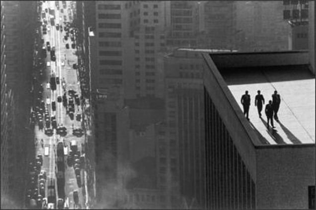 Men on a Rooftop, Sao Paulo, 1960. Burri brings the four men on the flat roof of a skyscraper closer by using a telephoto lens. The long-range, vertigo-inducing view and the simultaneity of the different elements contribute to the effect of the composition. © René Burri / Magnum Photos