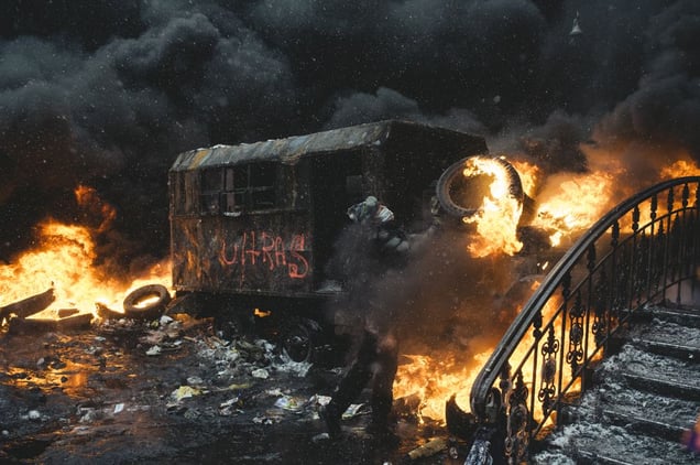 A protester carries a burning car ramp closer to the riot police cordon in the center of Kiev, Jan. 22, 2014