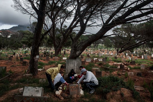 Members of the Oka Boys and Garo Boys visit Mansoer Odendaal's grave site in Observatory for his 18th birthday. Ryan, (red jacket) who was also stabbed, was with Mansoer the night he was killed on the bus. © Charlie Shoemaker