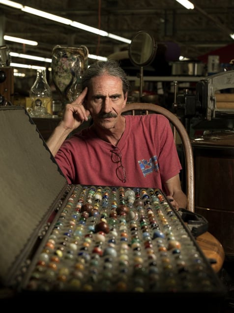 Richard Crowell sells antiques in the Clayton Indoor Flea Market in Clayton, GA. He's pictured here with his collection of vintage and rare marbles. © Forest McMullin