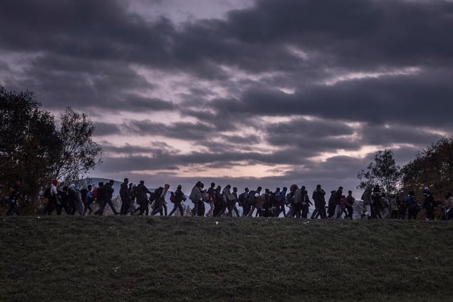 Migrants are escorted by Slovenian riot police to a registration camp outside Dobova, Slovenia, 23 October 2015.