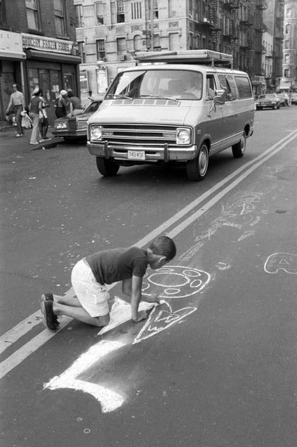 Boy writing OWL with chalk on street, Lower East Side, Manhattan, NYC, 1978  © Martha Cooper