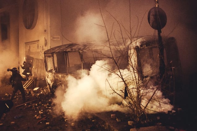 Protester try to clear the road and to take away burned bus on Hrushevskoho street under heavy fire of rubber bullets and stun grenades. Kiev, Jan. 19, 2014