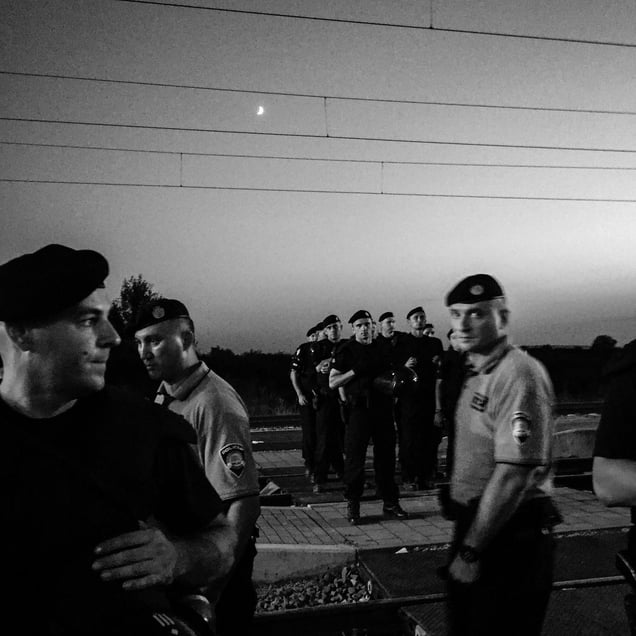 Croatian police guard the tracks as hundreds of refugees wait for trains in Tovarnik.