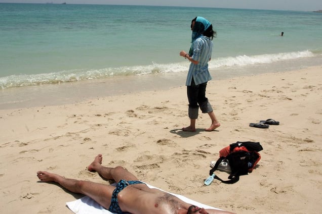 A Kish Island beach. While men are allowed to strip down to the tiniest of swim suits, Iranian women are obliged to  wear full Islamic dress even when going for a swim. Kish Island, IRAN - May 2006
© Copyright 1979-2009 Alfred Yaghobzadeh. All rights reserved.