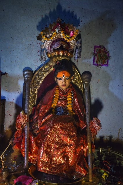 Unika Vajracharya (6), on her throne on her first day as the Kumari of Patan. A snake god is guarding her head, and her feet are resting on an offering tray. © Stephanie Sinclair for National Geographic Magazine