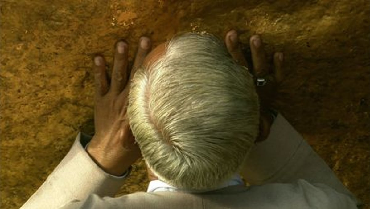 GOLDEN BOULDER, PRAYING <BR>A worshipper kisses the golden boulder at the peak of Mount Kyaikhtyo in Eastern Burma (Myanmar). © Peter Friedman and © Roger Manley