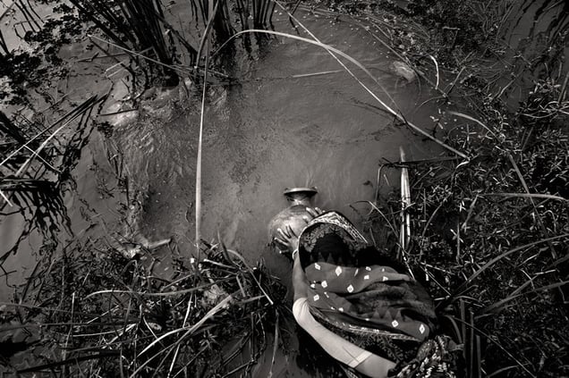 A woman collects drinking water from a sweet-water pond. Her two-hour journey needs to be performed twice a day. Bolabaria, Satkhira. © Munem Wasif/VU'