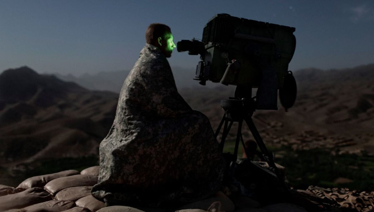 A U.S. Army soldier from the 10th Mountain Division surveys a road with a Long Range Acquisition Sight, on an observation post in the Tangi Valley, Wardak Province, Afghanistan, on September 4, 2009. © Adam Ferguson