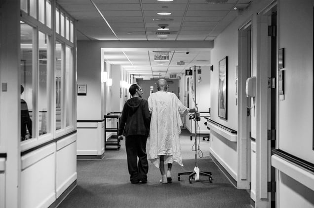 Recovering from a collapsed lung and managing a recent pneumonia diagnosis, Howard Borowick takes a walk down the hallways of Medical Oncology with the assistance of wife, Laurel Borowick, left, by his side. Greenwich, Connecticut. November, 2013 © Nancy Borowick