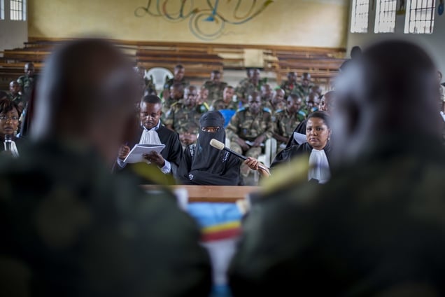 A victim, veiled to protect her identity, testifying before the closed military tribunal.  The accused are at the back.Temporary courtroom, Minova town, Democratic Republic of Congo, February 2014. © Diana Zeyneb Alhindawi Winner of the Humanitarian Visa díor award ñ International Committee of the Red (ICRC) 2015