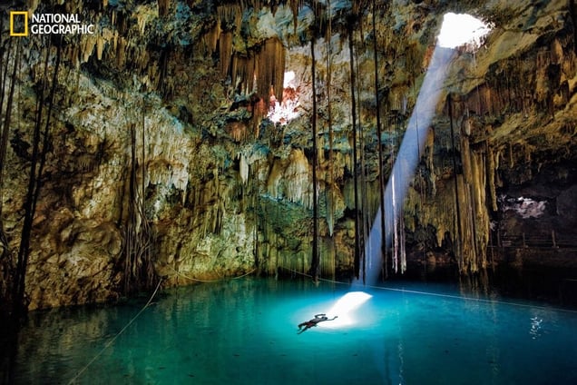 A single frame can transport us to one of our planet’s far-flung and beautiful places. In this one, stalactites and a sunbeam spotlight a swimmer in the Xkeken cenote, a natural well in the Yucatán thought by the Maya to lead to the underworld. From the October 125th anniversary issue of National Geographic magazine © John Stanmeyer/National Geographic