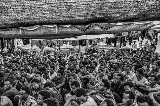 Migrants rescued off the Libyan coast gather on the deck of the Doctors WithoutBorders rescue ship and attend a service; Strait of Sicily, Mediterranean Sea, 03September 2015.