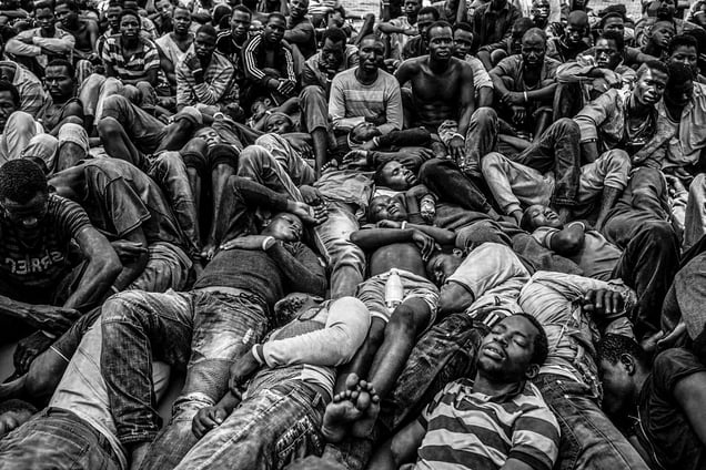 Exhausted Gambian and other West African migrants on the deck of a rescue ship off the coast of Libya