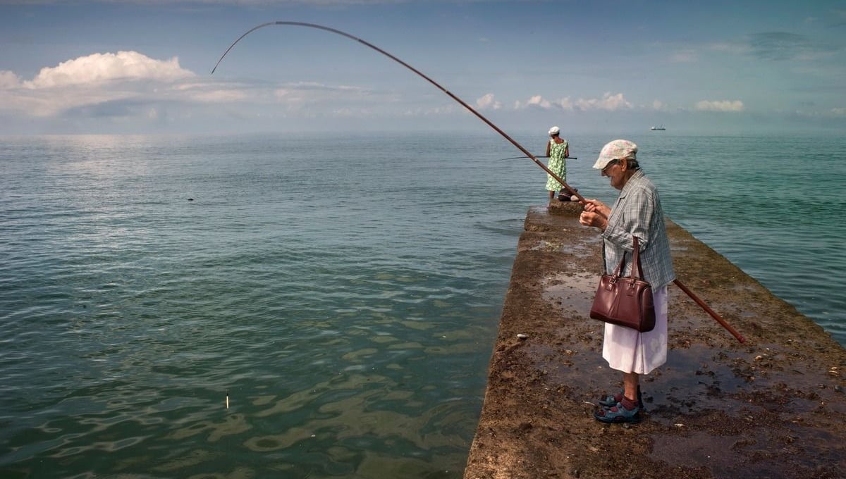 Georgia, Ochamchira, AbkhaziaNina (front) and her daughter fish from a concrete jetty. They need the fish to supplement their meagre diet. Nina get EUR 50 from her state pension. She used to work in a local fish canning factory but it was destroyed in the separatist war of 1992 - 1993 when Abkhazia effectively seceded from Georgia.© Petrut Calinescu