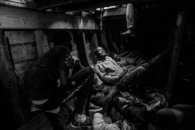 Migrants in the fetid hold of a wooden boat