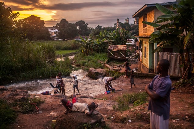 Residents of the town of Kailahun gather along a river at dusk. At the time, Kailahun district, in eastern Sierra Leone, was the most heavily affected by the ongoing Ebola outbreak, which originated across the nearby border with Guinea. (Pete Muller/Prime for the Washington Post)