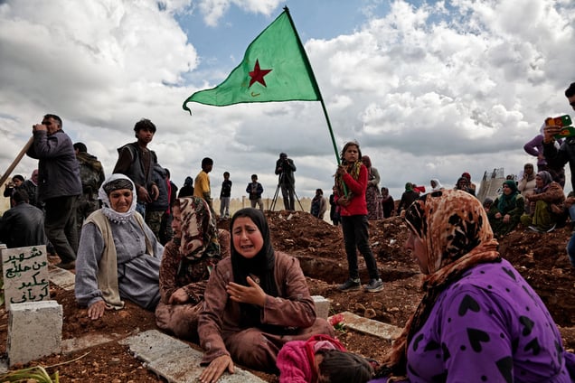 At a cemetery in Kobane, Syria, on 2 April, 2015, Kurdish people sit by the grave as they mourn their loved one, a YPG fighter (Kurdish People's Protection Unit), who was killed during clashes with the Islamic State in one of the frontlines of Kobane, Syria.