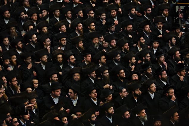 In a Stamford Hill Skwer synagogue Jewish men watch the Skwer Rebbe visiting from New York carry the new Sefer Torah (five books of Moses) into the Shul. Hundreds of men and women gathered to see the event take place.