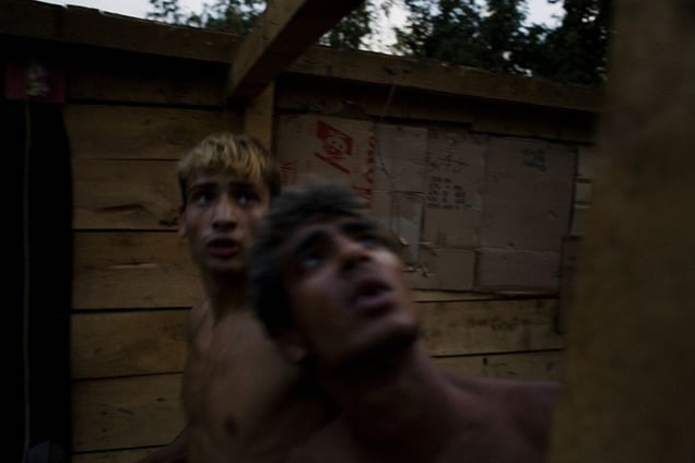 Elvis and his neighbor work to salvage building materials from an abandoned home in the Stara Gazela camp days before the settlement's destruction. © Matt Lutton