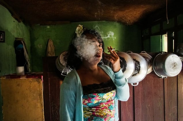 Nur smoking a cigarette in her kitchen