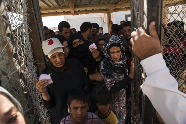 A Syrian family, the morning after they reached Jordan, registering at the UNHCR reception center. Zaatari Refugee Camp, Jordan, September 16, 2013. © Lynsey Addario / Getty Images Reportage for The New York Times