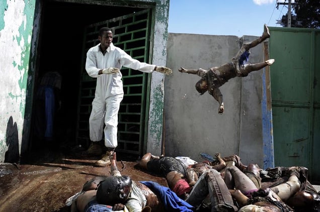 1st Prize General News Stories © Olivier Laban-Mattei, France, Agence France-Presse. Haiti earthquake aftermath, 15-26 January A man throws a dead body at the morgue of the general hospital, Port-au-Prince, 15 January