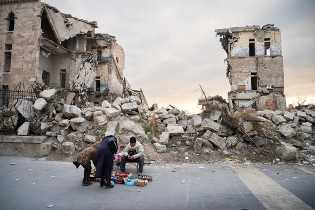 Hawl Al Qalaa St, Alep, Syrie.
 Sur la place de la citadelle d’ Alep, vestige d’un passé glorieux, un homme âgé vend des friandises à même le sol. Dans un pays rongé par la misère et la destruction, chaque centime gagné devient une question de survie.