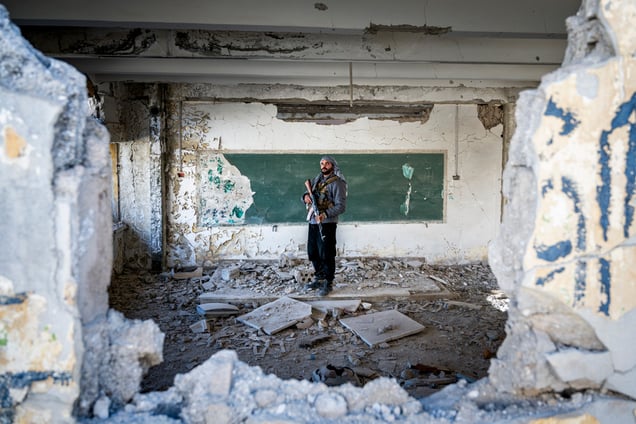 Jobar, Damas, Syrie.
Dans une école détruite par la guerre, un ancien élève devenu combattant pose là où il apprenait autrefois à lire et écrire.