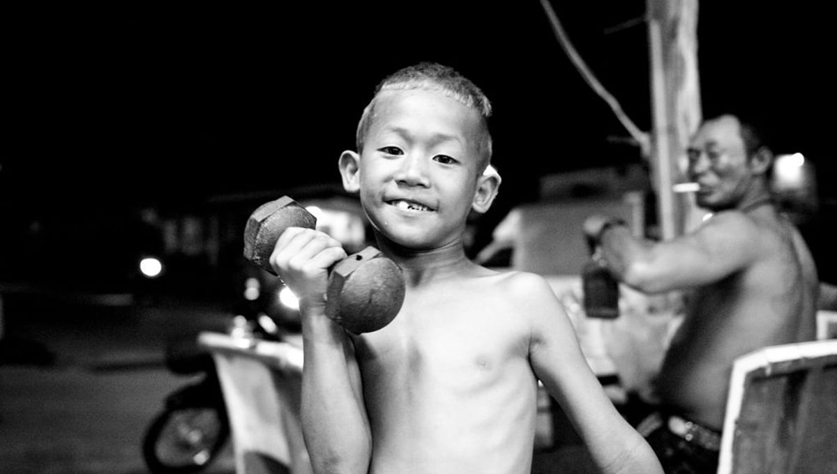 A boy, 7 years, wants to become a famous boxer. His father in the background is his trainer. © Sandra Hoyn