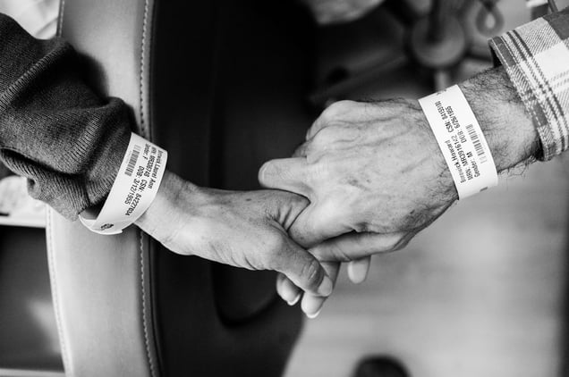 Like wedding rings, Laurel and Howie Borowick wear similar medical bracelets, which the nurses scan throughout their chemotherapy treatments together at the oncologists office. They do a dance, as both caretaker and patient and husband and wife, simultaneously trying to be there for the other but also trying to get through the day them selves. Greenwich, Connecticut. January, 2013 © Nancy Borowick
