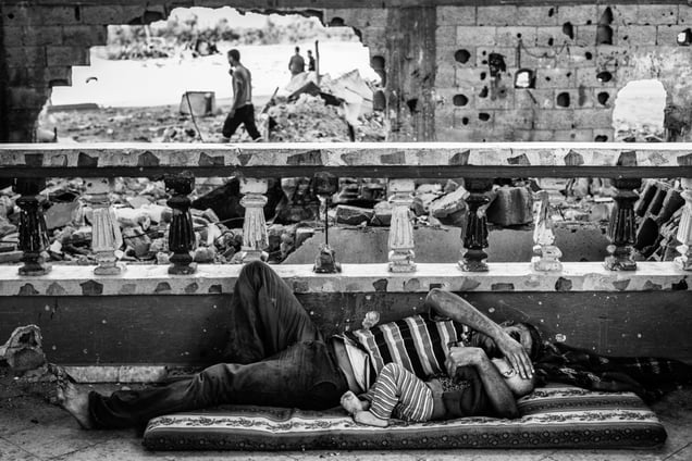 Gaza, Beit Hanoun: Abdel Abu Ouda and hisson are resting in the living room of theirhouse half destroyed during the bombing ofsummer 2014. © Virginie Nguyen Hoang