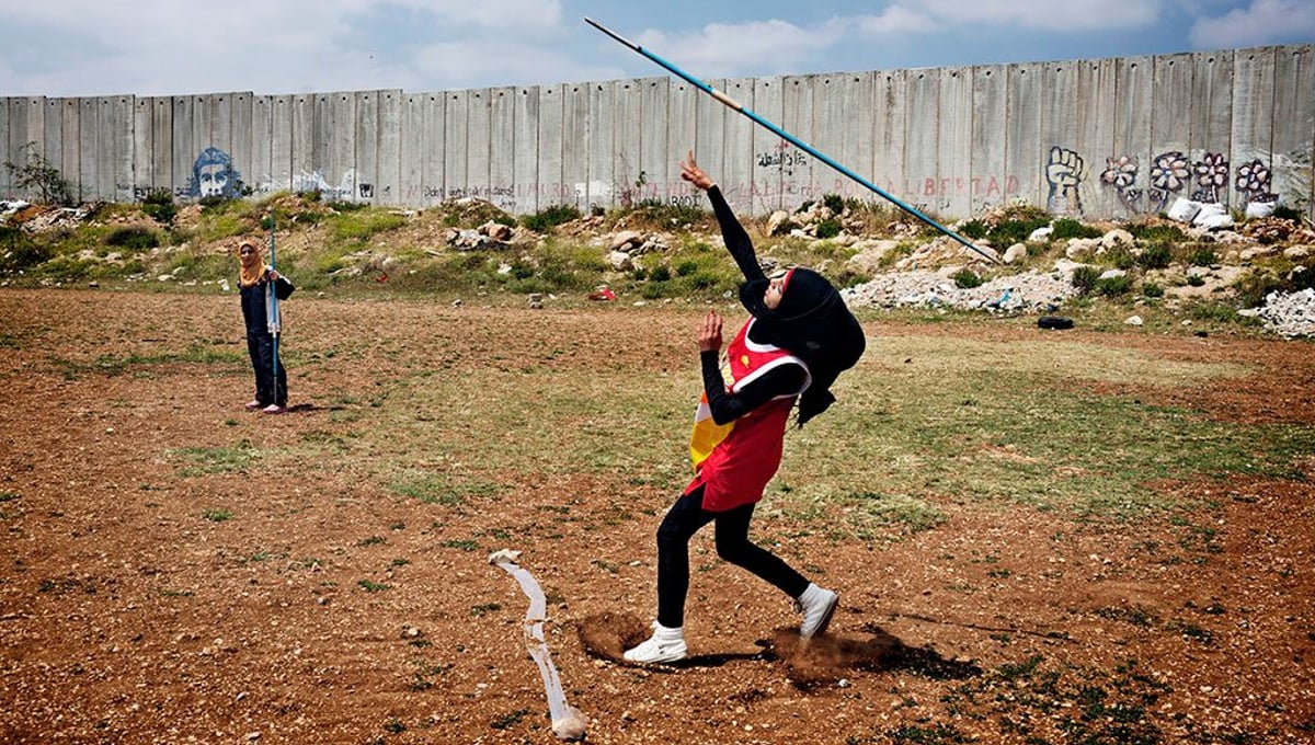 Students from the Al-Quds University javelin team wrap up the last practice before summer vacation in the West Bank city of Abu Dis, next to the Israeli Separation Wall.