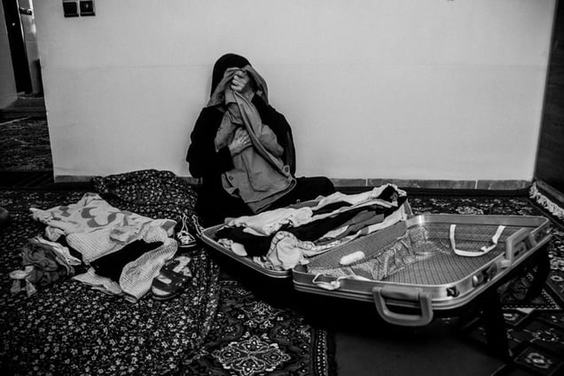 Many mothers keep their son's photos, clothes and other belongings, to help bring them solace. Anbar Jaberi (72) cries as she embraces some of her son Nematollah's clothing _IRAN_ Illam