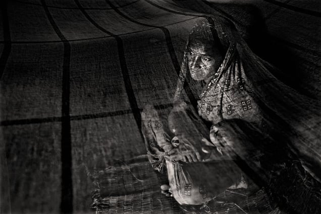 Sorifa Khatun (30) rocks one of her seven children to sleep. Her husband, Kased Mali, was killed by a tiger some six months ago. Gabura, Satkhira. © Munem Wasif/VU'