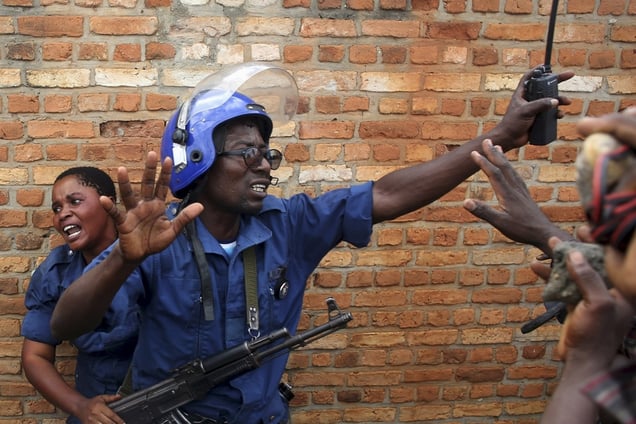 A policeman trying to protect a female police officer accused of shooting a protester. Opponents of the president and his decision to run for a third term chased, beat and stoned the woman, who was later handed back to the police.Buterere neighborhood, Bujumbura, Burundi, May 12, 2015. © Goran Tomasevic / Reuters