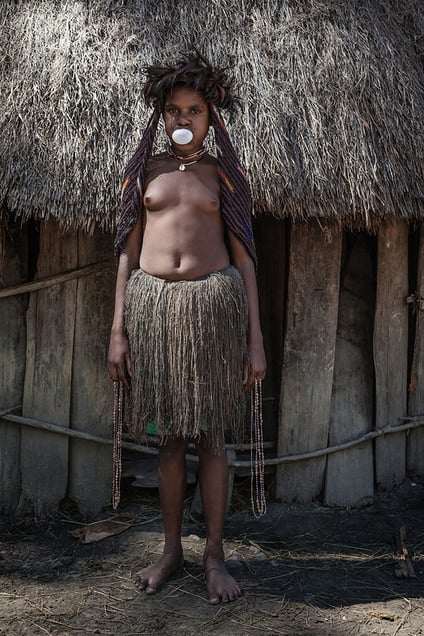 Justina, 12, holds beads, which she sells to tourists at the price of 20 000 rupiahs (2 USD) each. She attends the fourth grade in a primary school and uses money for buying lollipops and chewing gums in the market.Jiwika village, West Papua Province.